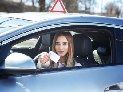 joyful-girl-driving-a-training-car-with-a-drivers-license-card-in-her-hands-1.jpg